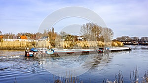 Trawler navigating a rive . Cargo ship.