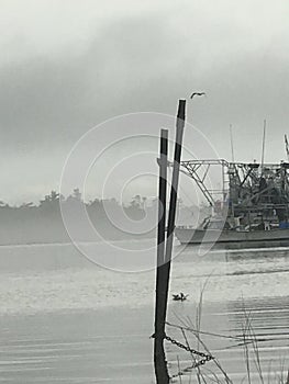 Trawling boat docked in Plaquemines Parish Louisiana on a foggy morning.
