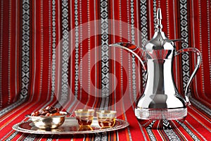 A tray of Arabian tea cups is placed on Arabian woven fabric