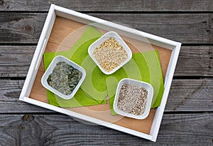 Tray with bowls filled with pumpkin seeds, buckwheat and sunflower seeds