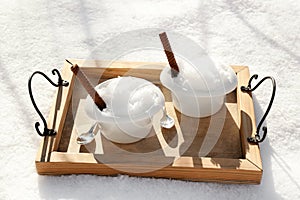 Tray with bowls of tasty ice cream and waffle rolls