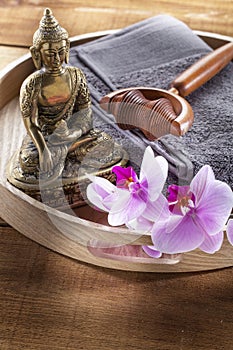 Tray with Buddha and orchid flowers for spirituality and massage