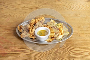 Tray of chicken fingers in batter with egg and breadcrumbs, parsley,