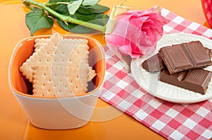 An tray with chocolate and a pink rose