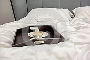 Tray with coffee in a large bed in a king size bedroom