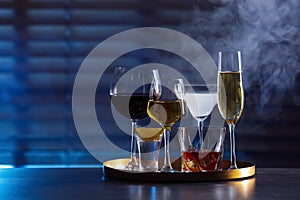 Tray with different alcohol drinks on table indoors