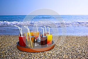 Tray with drinks on the beach sand