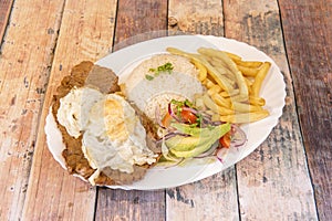 Tray of Ecuadorian churrasco with beef steak, fried egg on top and various garnishes of French fries, white rice