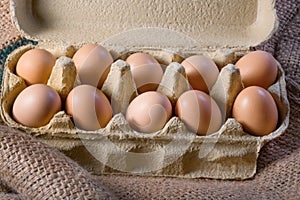 Tray of fresh eggs from a farm on burlap, close up. Chicken, egg