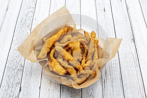Tray with fried breaded chicken strips with brown greaseproof paper photo