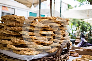 Tray full of Greek traditional round sesame bread rings, displayed in a street market with bokeh background
