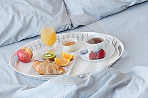 Tray with healthy breakfast on a bed