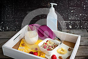 tray with healthy muesli, oat milk, face mask and disinfectant bottle