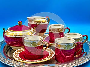 a tray holding several colorful colored tea cups and saucers