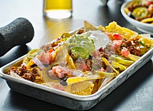 Tray of loaded mexican nachos with beef and queso cheese photo