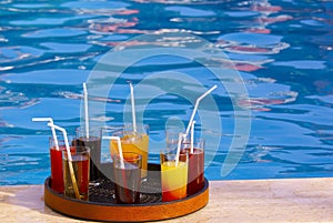 Tray with many drinks on the poolside