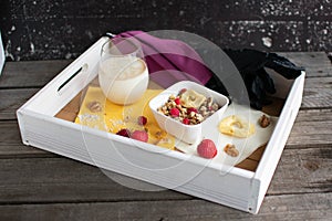 tray with muesli, oat milk, purple face mask and disposable gloves