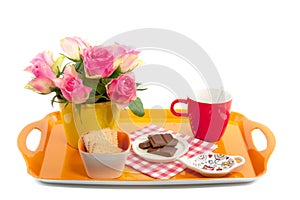 A tray with pink roses and sweets