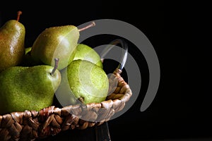 Tray with ripe pears on table against dark background, closeup