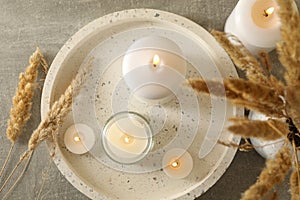 Tray with scented candles and reed on gray table