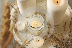 Tray with scented candles and reed on gray table photo