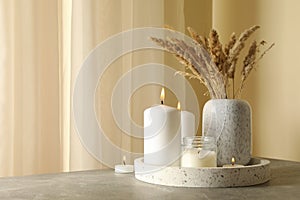 Tray with scented candles and reed on gray table