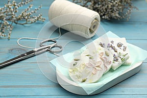 Tray with scented sachets on light blue wooden table