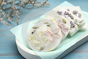 Tray with scented sachets on light blue wooden table, closeup