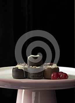Tray with a selection of chocolates and red curranrts. photo