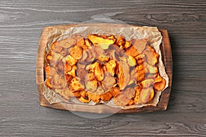 Tray with sweet potato chips on wooden table