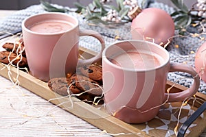 Tray with tasty cookies and cups of hot cocoa drink