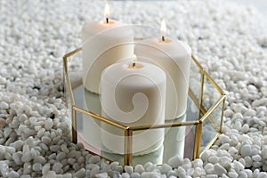 Tray with three white burning candles