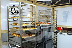 Trays with fresh baked rolls on a trolleys, electric oven, mini bakery production hall
