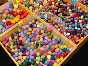 trays full of colorful balls made of boiled wool of various sizes on sale in the pastime shop