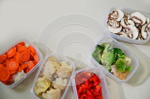 Trays with raw vegetables for freezing. Stocking up for winter storage in plastic containers, puts in a box to freeze