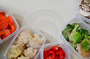 Trays with raw vegetables for freezing. Stocking up for winter storage in plastic containers, puts in a box to freeze