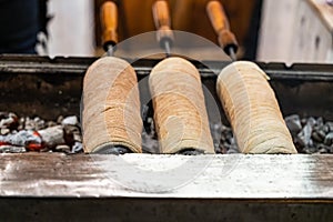 Trdelnik dessert baked goods of europe is cooked on fire in the shape of a cone close-up