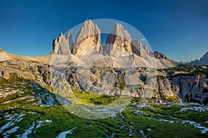 Tre Cime di Lavaredo Mountains with green grass, Dolomites Alps, Italy