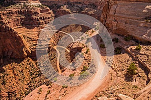 A treacherous road descends into a desert canyon.