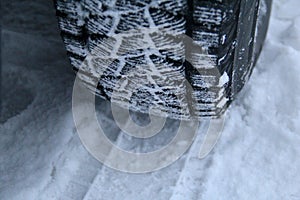 Tread area of winter tire packed with the snow close up