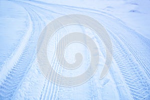 Tread texture of car wheels snow. Winter road in January, December. Rural area and background of tractor tracks in the snow