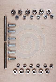 Treaded fasteners bolts and nuts at wooden background with copy space for your own text