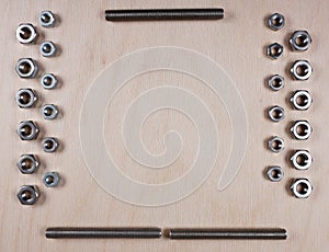 Treaded fasteners bolts and nuts at wooden background with copy space for your own text