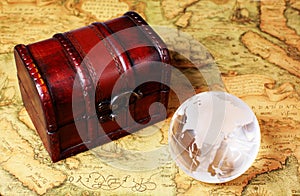 Treasure box and globe on ancient map background