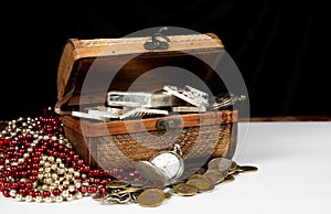 Treasure box on table with gold silver coins and bars
