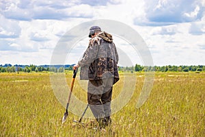 Treasure hunter in the field with a metal detector