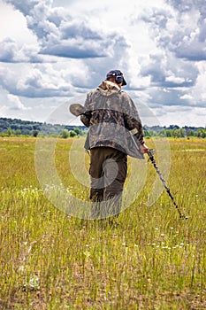 Treasure hunter in the field with a metal detector