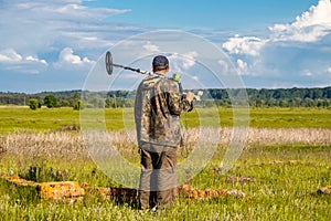 Treasure hunter in the field with a metal detector