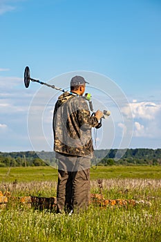 Treasure hunter in the field with a metal detector