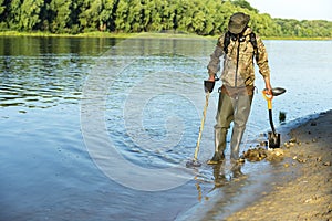 Treasure hunter is looking for a metal detector in the river